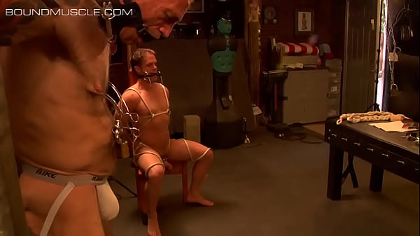 Muscular guys tie each other up with ropes and chains